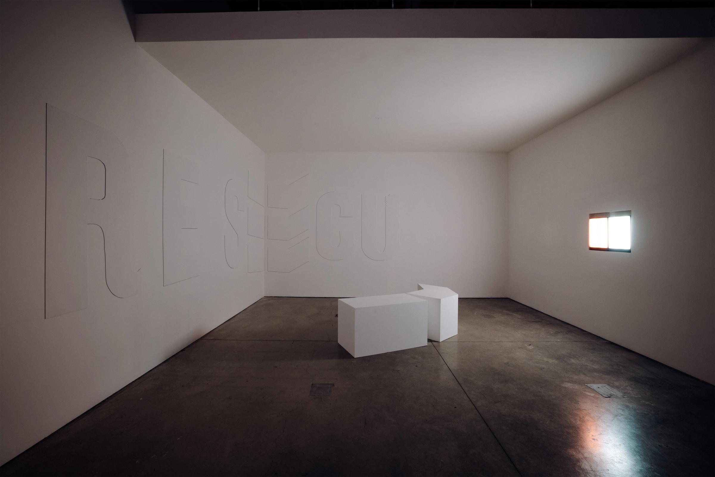 Three walls frame two white stools in the center. On the rightmost wall, a bright, cool light source colors the room a cool white color.
